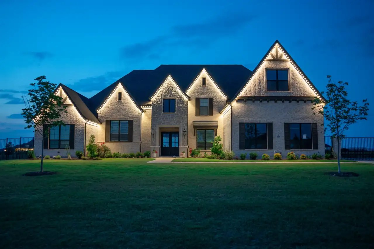 Front view of a brick home with permanent outdoor LED lighting along the roofline