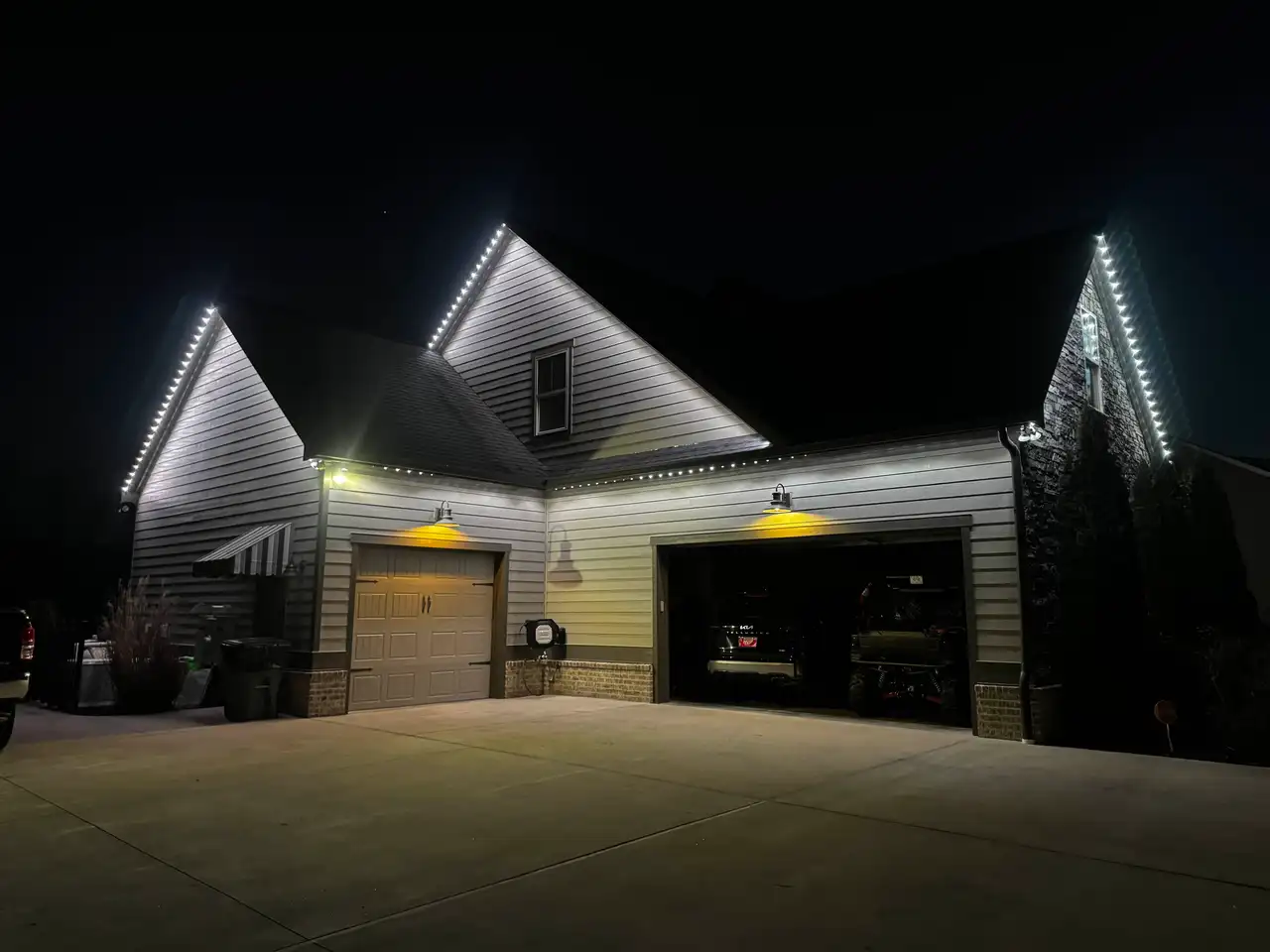 Home in Prairie Village, Chattanooga at night with white permanent LED lighting along the gables and garage roofline