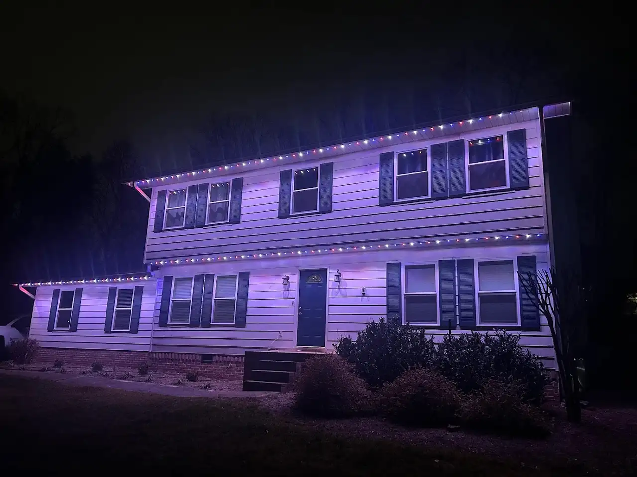 Two-story home in East Brainerd, Chattanooga at night with multicolor permanent LED lighting along the rooflines